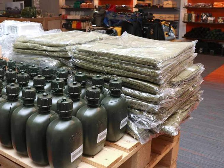 Singapore Armed Forces (SAF) issue items, including 1-liter army green water bottles and folded green towels, commonly stocked at Lifestyle Mart locations for NSmen