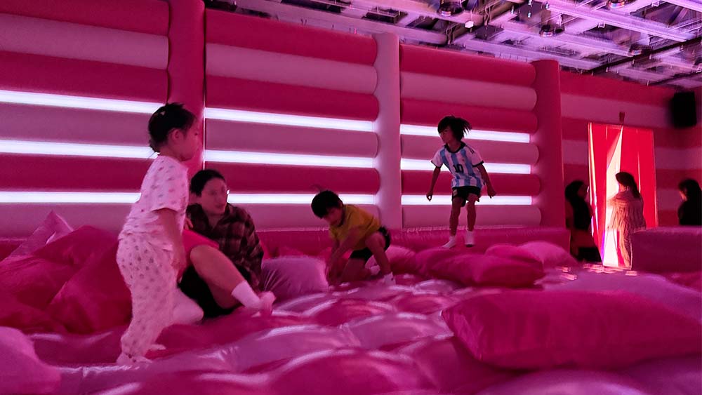 Cushion Clash, children playing in a vibrant, pink-themed inflatable room, which is part of Dopamine Land, located in Singapore.