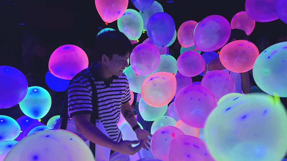 Neon Nebula, enjoying the immersive, neon-colored balloon room at Dopamine Land, a multisensory experience located at Resorts World Sentosa in Singapore.