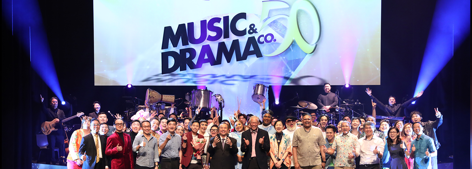 A group of performers and officials celebrating the 50th anniversary of the Music & Drama Company (MDC) in Singapore.