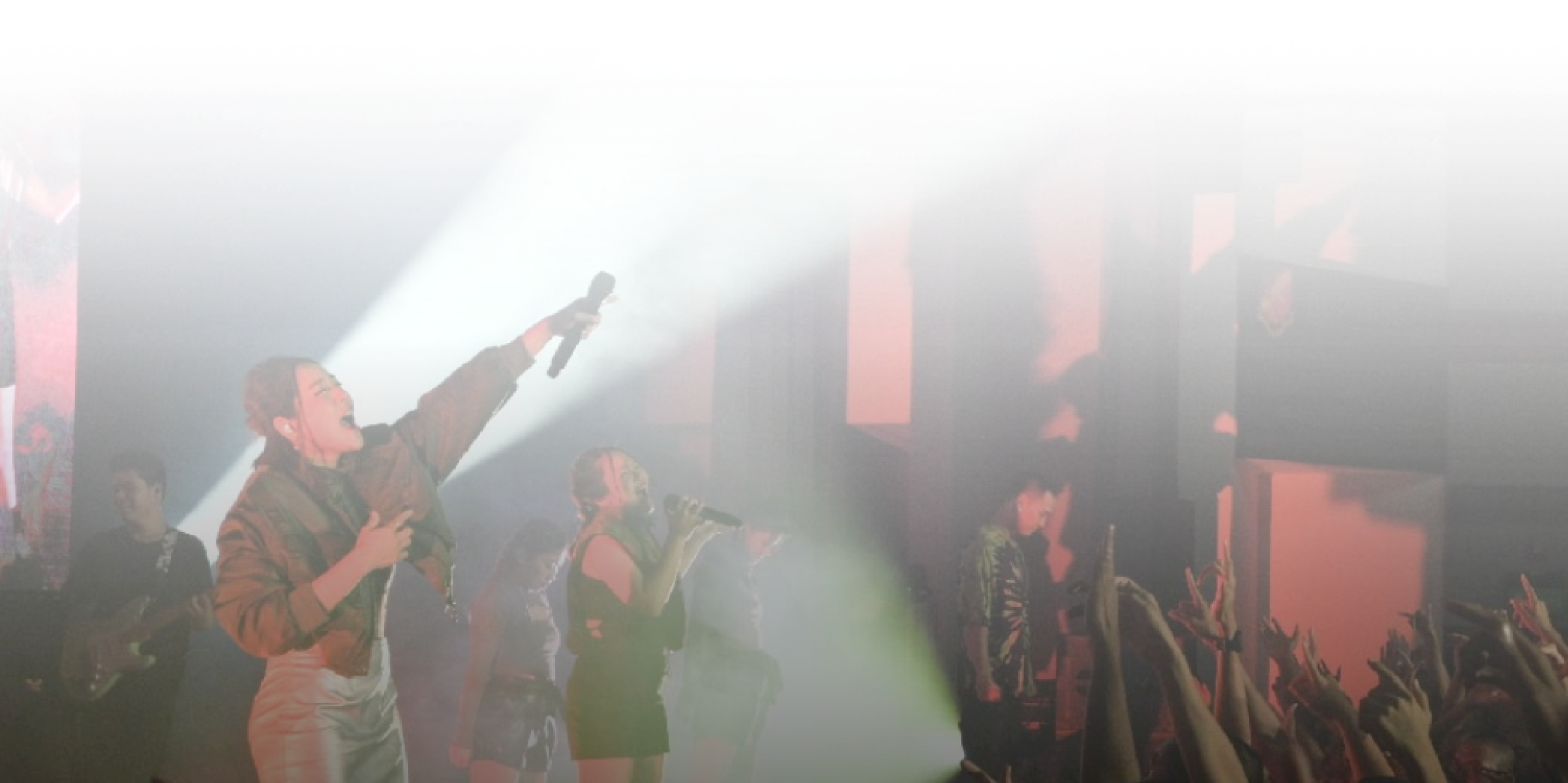 Singer holding a microphone under a spotlight